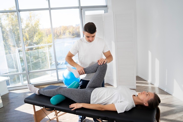 Physical therapist helping a patient with leg exercises